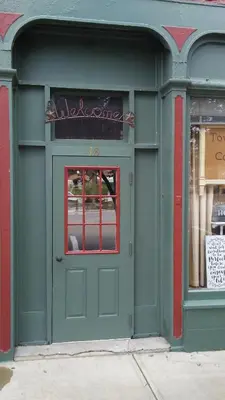 a green door of a store with a window at The Historic Hideaway in McConnelsville