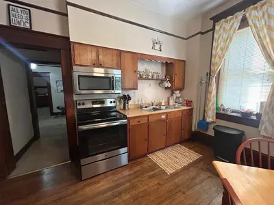 a kitchen with stainless steel appliances and wooden cabinets at The Historic Hideaway in McConnelsville