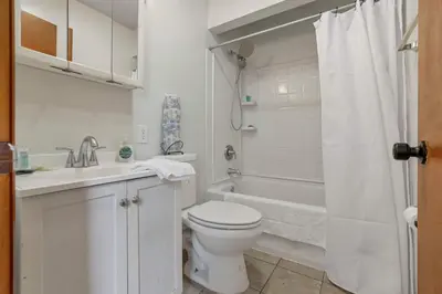 a white bathroom with a toilet and a bath tub at Spacious 4BR Ranch Near Easton Perfect for Families & Work Groups in Columbus