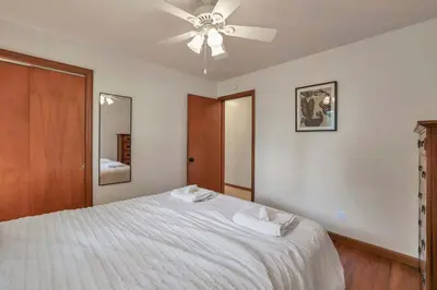a bedroom with a white bed with a ceiling fan at Spacious 4BR Ranch Near Easton Perfect for Families & Work Groups in Columbus