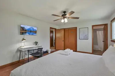 a bedroom with a bed with a ceiling fan and a desk at Spacious 4BR Ranch Near Easton Perfect for Families & Work Groups in Columbus