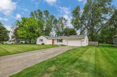 a white house with a driveway in a yard at Spacious 4BR Ranch Near Easton Perfect for Families & Work Groups in Columbus