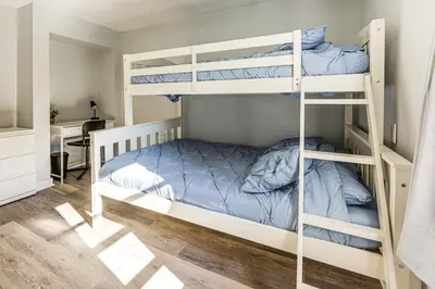 a bedroom with two bunk beds and a desk at Walk and Bike Great Miami River Trail Dayton Home in Dayton