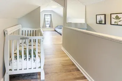 a white crib in a room with a staircase at Walk and Bike Great Miami River Trail Dayton Home in Dayton