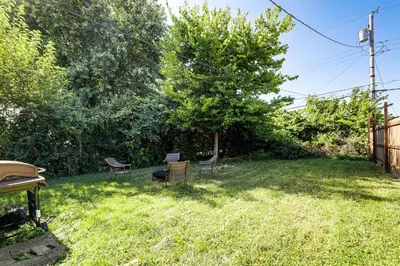 a yard with two chairs and a tree at Walk and Bike Great Miami River Trail Dayton Home in Dayton