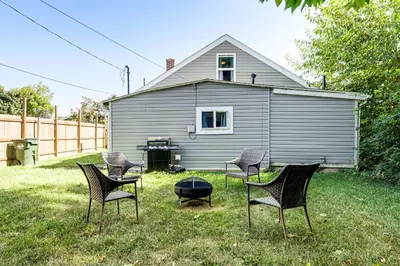 a group of chairs sitting in the grass in front of a house at Walk and Bike Great Miami River Trail Dayton Home in Dayton