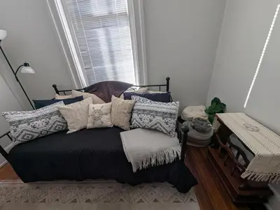 a bedroom with a bed with pillows and a window at Heart of OTR -Stadiums, Museums, Nightlife, Casino in Cincinnati