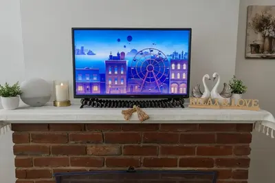 a tv sitting on top of a fireplace at Heart of OTR -Stadiums, Museums, Nightlife, Casino in Cincinnati