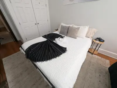a large white bed with black and white pillows at Heart of OTR -Stadiums, Museums, Nightlife, Casino in Cincinnati