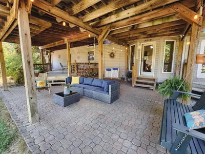 a porch with a blue couch on a patio at Spacious 5 bedroom 16 plus guests on 14 acres with fishing pond in Lagrange