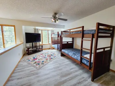 a room with bunk beds and a flat screen tv at Spacious 5 bedroom 16 plus guests on 14 acres with fishing pond in Lagrange