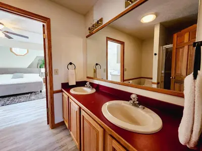 a bathroom with two sinks and a large mirror at Spacious 5 bedroom 16 plus guests on 14 acres with fishing pond in Lagrange