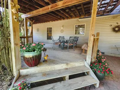 a porch of a house with a table and flowers at Spacious 5 bedroom 16 plus guests on 14 acres with fishing pond in Lagrange