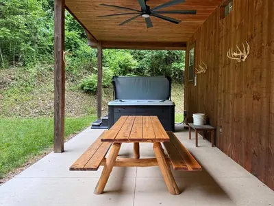 a picnic table and a grill on a patio at Secluded, Luxuriously Remodeled, Gaming, Hot Tub! in South Bloomingville