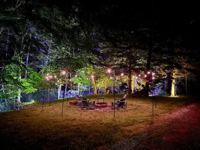 a group of chairs sitting under a tree at night at Secluded, Luxuriously Remodeled, Gaming, Hot Tub! in South Bloomingville