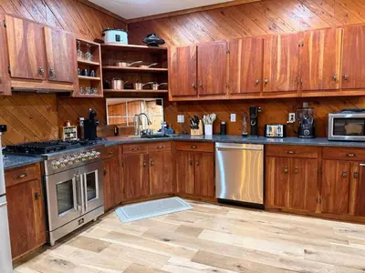 a kitchen with wooden cabinets and stainless steel appliances at Secluded, Luxuriously Remodeled, Gaming, Hot Tub! in South Bloomingville
