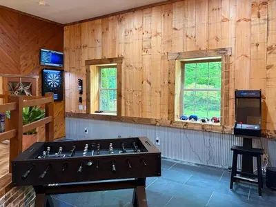 a ping pong table in a room with wooden walls at Secluded, Luxuriously Remodeled, Gaming, Hot Tub! in South Bloomingville