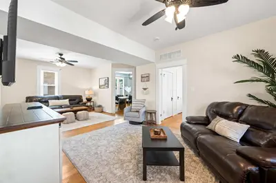 a living room with a leather couch and a table at Double Game Rooms! - 4BR Only 7 Min to Ark in Williamstown
