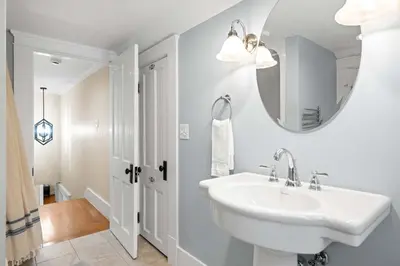 a white bathroom with a sink and a mirror at Double Game Rooms! - 4BR Only 7 Min to Ark in Williamstown