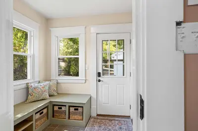 a hallway with a bench and two windows at Double Game Rooms! - 4BR Only 7 Min to Ark in Williamstown