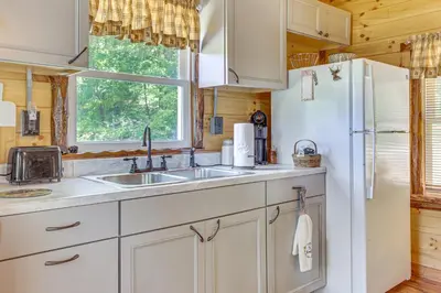a kitchen with a sink and a refrigerator at Charming Couples Cabin on 40 Acres in Zanesville in Zanesville