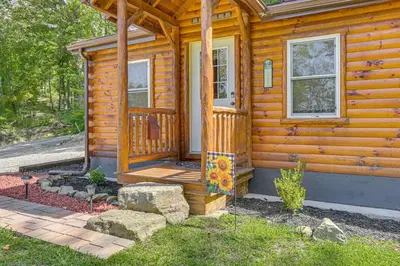 a wooden cabin with a porch and a door at Charming Couples Cabin on 40 Acres in Zanesville in Zanesville