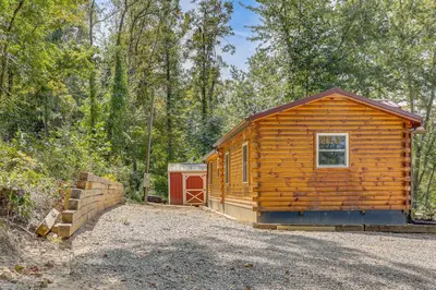 a small wooden cabin in the middle of a forest at Charming Couples Cabin on 40 Acres in Zanesville in Zanesville