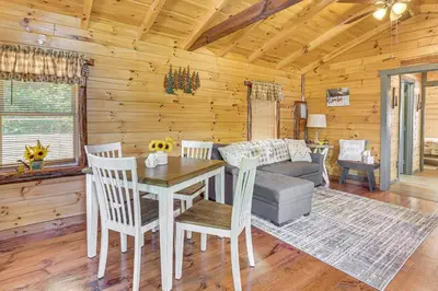 a dining room with a table and chairs and a couch at Charming Couples Cabin on 40 Acres in Zanesville in Zanesville