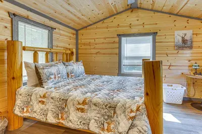 a bedroom with a bed in a log cabin at Charming Couples Cabin on 40 Acres in Zanesville in Zanesville