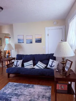 a living room with a blue couch and two lamps at The Riverstone Getaway in historical Madison, IN in Madison