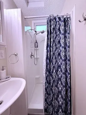 a bathroom with a shower curtain and a sink at The Riverstone Getaway in historical Madison, IN in Madison