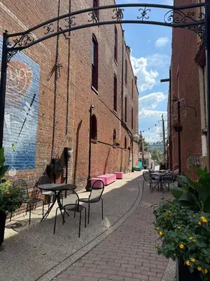 an alley with tables and chairs on a street at The Riverstone Getaway in historical Madison, IN in Madison