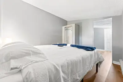 a bedroom with a white bed with a blue blanket on it at Main Floor Tremont Home with KING Bed, Mins From DT, Pet Friendly in Cleveland
