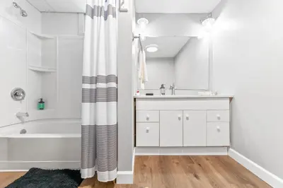 a white bathroom with a tub and a sink at Main Floor Tremont Home with KING Bed, Mins From DT, Pet Friendly in Cleveland