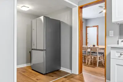 a stainless steel refrigerator in a kitchen with a table at Main Floor Tremont Home with KING Bed, Mins From DT, Pet Friendly in Cleveland