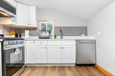 a kitchen with white cabinets and stainless steel appliances at Main Floor Tremont Home with KING Bed, Mins From DT, Pet Friendly in Cleveland