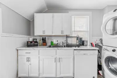a white kitchen with a sink and a dishwasher at Group Suite in Tremont, 4 TV's, Pet Friendly in Cleveland