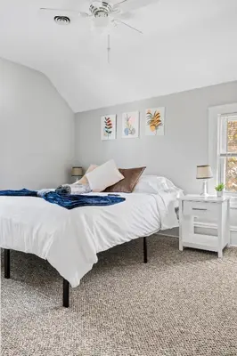 a white bedroom with a bed and a window at Group Suite in Tremont, 4 TV's, Pet Friendly in Cleveland