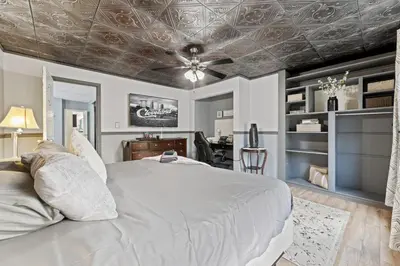a bedroom with a white bed and a ceiling at Luxe Suite with Pool Table, King Bed, 3 TVs, & Free Parking in Cleveland