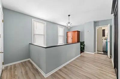 an empty living room with blue walls and wood floors at Luxe Suite with Pool Table, King Bed, 3 TVs, & Free Parking in Cleveland
