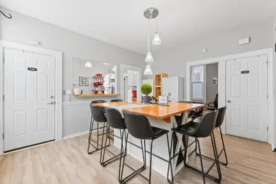 a kitchen with a wooden table and black chairs at Luxe Suite with Pool Table, King Bed, 3 TVs, & Free Parking in Cleveland