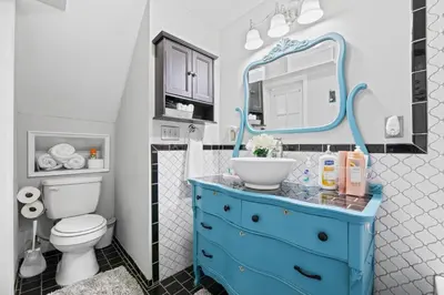a bathroom with a blue dresser with a sink and a mirror at Luxe Suite with Pool Table, King Bed, 3 TVs, & Free Parking in Cleveland