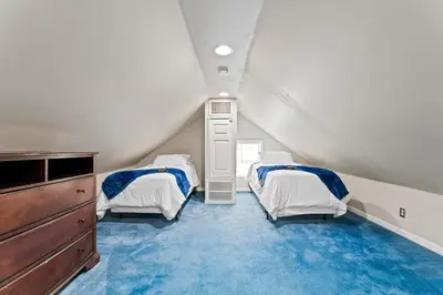 a attic room with two beds and a dresser at Ohio City 4 Bed 3 TV Free Parking Mins to DT in Cleveland
