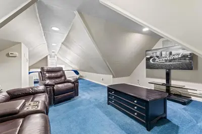 a attic living room with a couch and a tv at Ohio City 4 Bed 3 TV Free Parking Mins to DT in Cleveland
