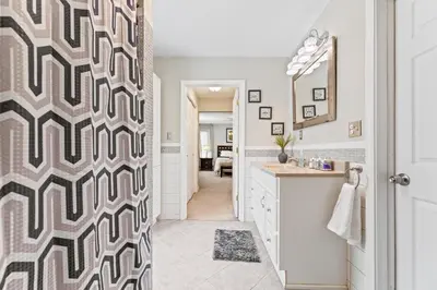 a bathroom with a geometric patterned shower curtain at Ohio City 4 Bed 3 TV Free Parking Mins to DT in Cleveland