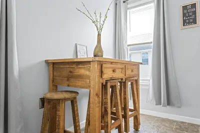a wooden table with stools and a vase on it at Ohio City 4 Bed 3 TV Free Parking Mins to DT in Cleveland