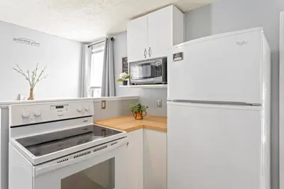 a kitchen with white appliances and a white refrigerator at Ohio City 4 Bed 3 TV Free Parking Mins to DT in Cleveland