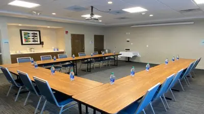 a conference room with a long wooden table and blue chairs at Holiday Inn Express & Suites Toledo South - Perrysburg by IHG in Perrysburg Heights