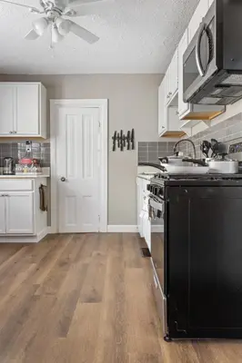 a kitchen with white cabinets and a black stove top oven at KING Bed Entire House Near DT in Cleveland