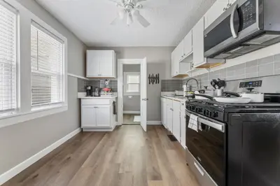 a kitchen with white cabinets and a black stove top oven at KING Bed Entire House Near DT in Cleveland
